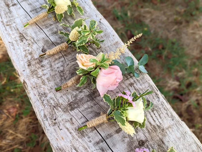 Boutonnière champêtre avec rose blanche, feuillage panaché et astilbe pour le mariage de Karine.