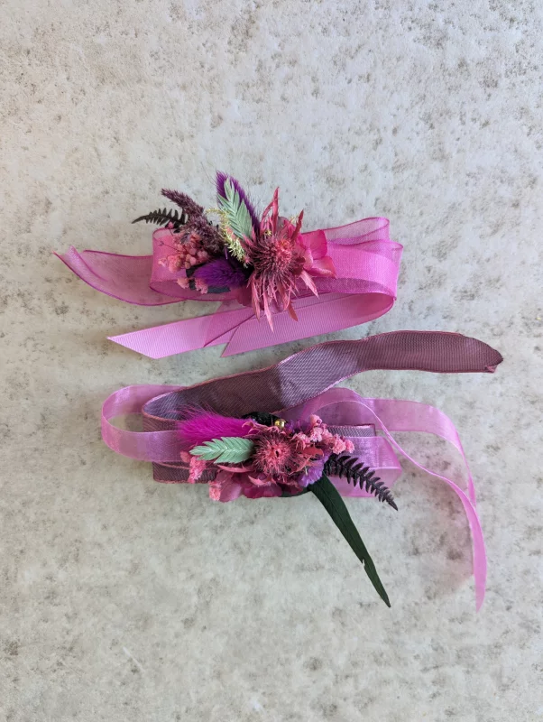 Rustic-chic floral bracelets with rose-violet thistle, pampas grass and ribbons for a spring wedding.