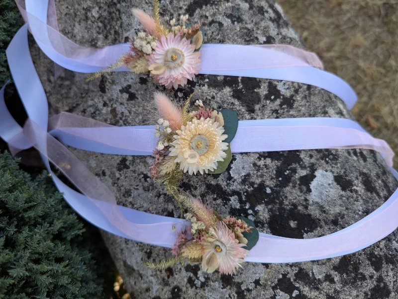 Three bohemian floral bracelets with dried flowers and pampas, tied with pastel ribbons.