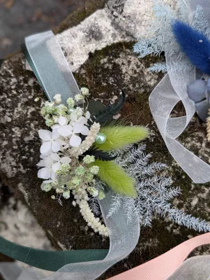 Bohemian botanical floral bracelet with dried green flowers, white hydrangeas, and green ribbons.