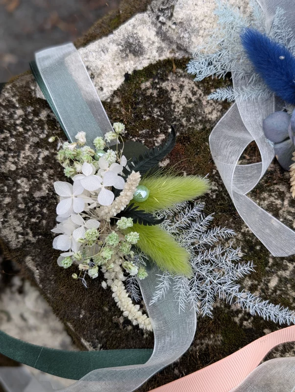 Bohemian botanical floral bracelet with dried green flowers, white hydrangeas, and green ribbons.