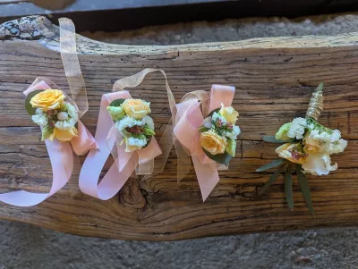 Bracelet floral de mariage classique, avec des roses jaunes pâles, des petites fleurs blanches et du feuillage vert sauge.
