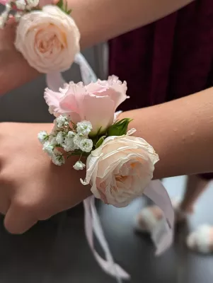 Bracelet floral de mariage classique avec roses roses pâles, lisianthus et gypsophile pour demoiselles d'honneur.