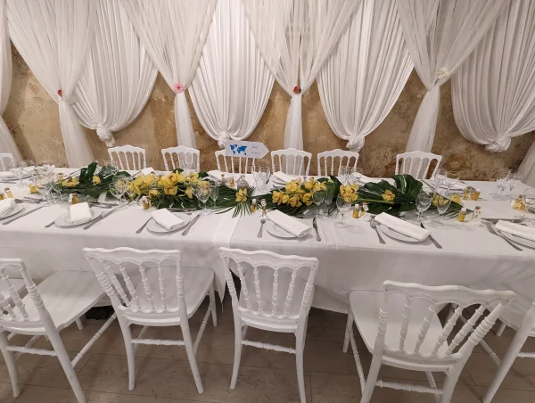 Décoration de table d'honneur exotique avec orchidées jaunes et feuilles de Monstera pour un mariage d'été.