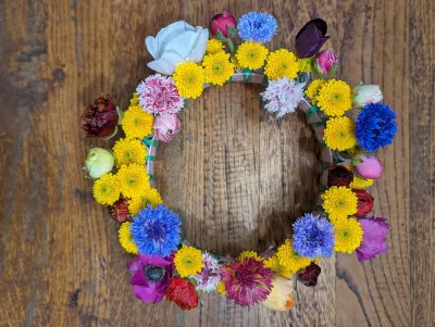 Country-style wedding table centrepiece with purple anemones, pink carnations and yellow and blue wildflowers.