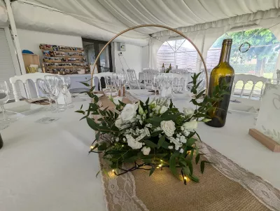 Centre de table original en cercle avec roses, lisianthus et eucalyptus, ambiance champêtre pour mariage.