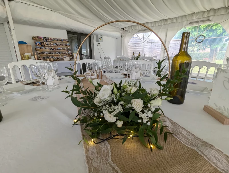 Distinctive circular table centrepiece with roses, lisianthus and eucalyptus, for a wedding with rustic charm.