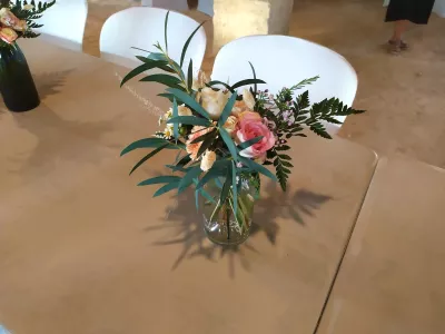 Détail d'un centre de table bohème champêtre avec dahlia, roses, blé et feuillage, pour un mariage à Escalans.