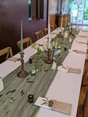 Décoration de table d'honneur champêtre avec des dahlias, gypsophile, eucalyptus et branches d'olivier à Avensan.