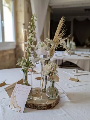 Élégant centre de table de mariage bohème avec delphinium, roses, pampa et bougies flottantes.