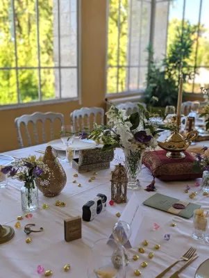 Sophisticated rustic table centrepiece with purple and white flowers, Aladdin theme, wedding.