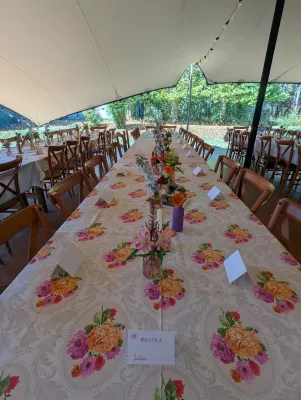 Ambiance champêtre pour la table d'honneur d'un mariage, avec des centres de table floraux variés et des motifs de fleurs sur la nappe.