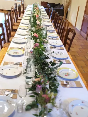 Longue guirlande florale champêtre pour centre de table de mariage, ornée de roses pêche, de feuillage verdoyant.