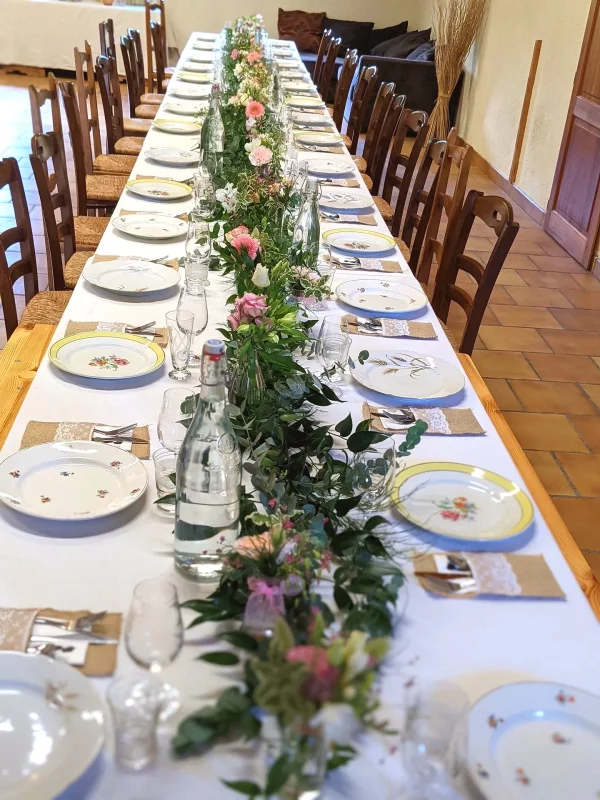 Longue guirlande florale champêtre pour centre de table de mariage, ornée de roses pêche, de feuillage verdoyant.