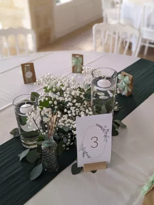 Centre de table champêtre et lumineux avec gypsophile, eucalyptus et bougies flottantes.
