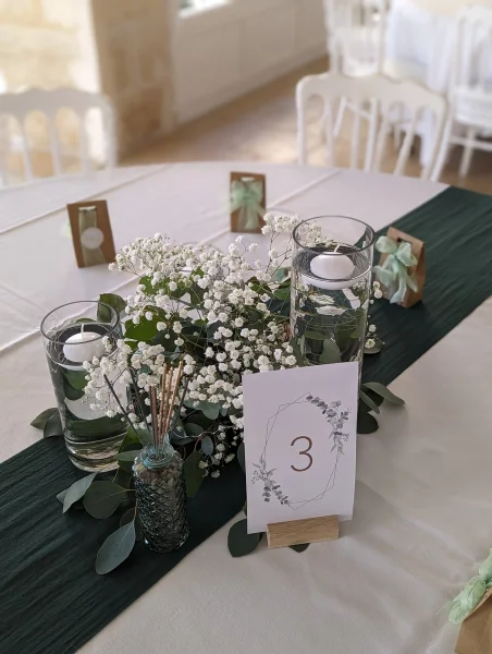 Centre de table champêtre et lumineux avec gypsophile, eucalyptus et bougies flottantes.