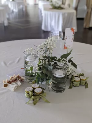 Centre de table avec gypsophile, eucalyptus et bougies flottantes dans des vases en verre, style champêtre.