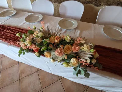 Composition de table d'honneur bohème avec roses pêche, lisianthus et palmier séché pour mariage de Morgane à Vayres.