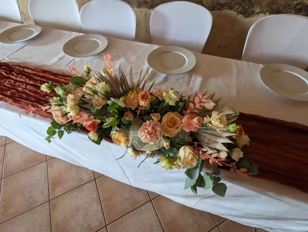 Composition de table d'honneur bohème avec roses pêche, lisianthus et palmier séché pour mariage de Morgane à Vayres.
