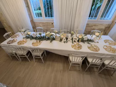 Centre de table élégant pour la table d'honneur, avec des roses, du gypsophile, de l'eucalyptus et des bougies, style classique.