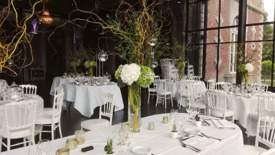Centre de table mariage classique et moderne avec hortensias blancs et verts, branches décoratives, verrerie élégante.