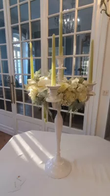Large sophisticated country-style table centrepiece with hydrangeas, roses, and candles for a wedding.