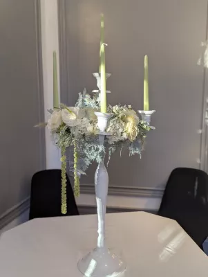 Large sophisticated country-style table centrepiece with hydrangeas, roses, and candles for a wedding.