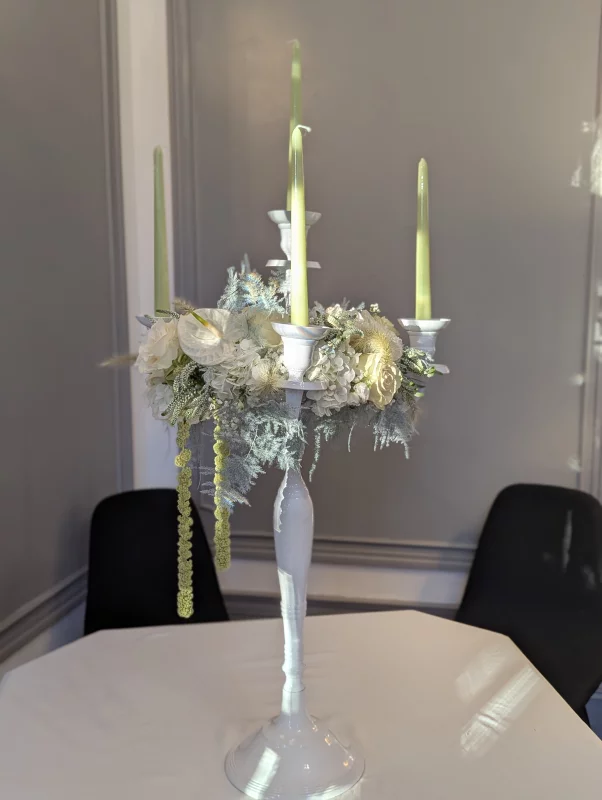 Large sophisticated country-style table centrepiece with hydrangeas, roses, and candles for a wedding.