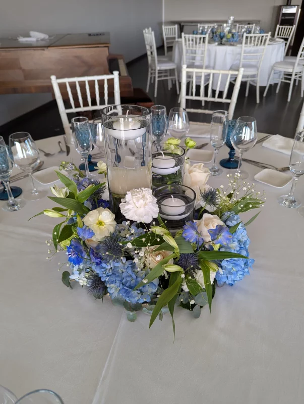 Rustic chic table centrepiece with blue hydrangeas, white roses and carnations for Salomé's wedding.