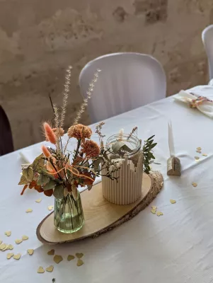 Centre de table mariage boheme avec hortensia seche terracotta, graminees beige et photophore.