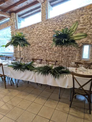 Lush exotic table centrepiece with large monstera leaves and palms for an elegant and luxuriant wedding.
