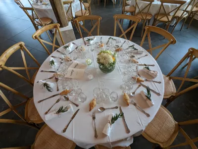 Ambiance de mariage champêtre au Domaine Le Herre, tables décorées de centres floraux blancs et jaunes, feuillage.