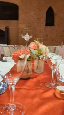Close-up view of a sophisticated rustic centrepiece with carnations, roses, and foliage.
