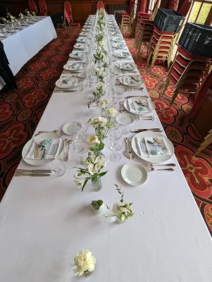Décoration florale de table de mariage minimaliste avec petits arrangements de fleurs blanches et verdure pour la réception à Pessac.