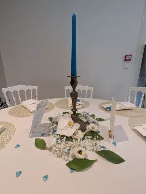 Sophisticated country wedding table centrepiece with white orchid, gypsophila, and blue candle.