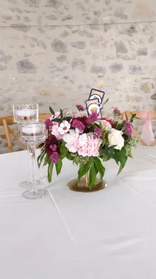 Centre de table champêtre sophistiqué avec pivoines, roses et œillets, thème Monopoly.