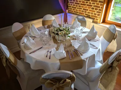 Centre de table mariage classique avec roses blanches, arums et gypsophile pour une ambiance printanière élégante.