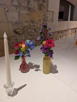 Sophisticated country-style table centrepiece featuring fuchsia roses, blue delphiniums and purple scabiosas for a wedding.