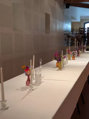 Long wedding table with sophisticated rustic table centrepieces, roses, delphiniums and candles.