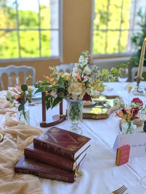 Sophisticated rustic table centrepiece with cream rose, white delphinium and orange alstroemeria for a wedding.