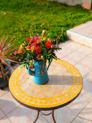 Centre de table mariage champêtre avec roses rouges, dianthus et feuillage vert. Composition florale riche et chaleureuse pour un mariage hivernal.