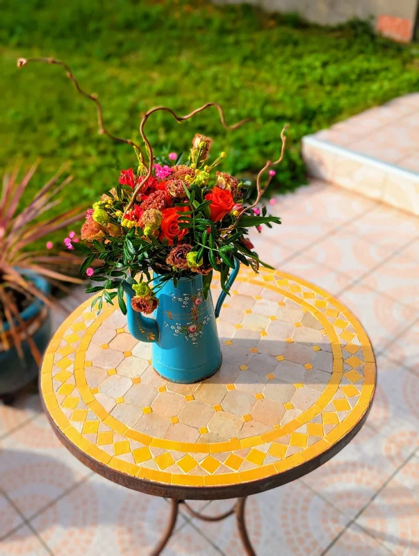 Centre de table mariage champêtre avec roses rouges, dianthus et feuillage vert. Composition florale riche et chaleureuse pour un mariage hivernal.