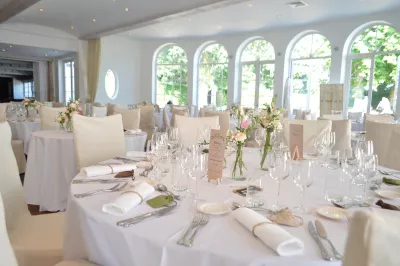 Centre de table élégant pour mariage, avec roses poudrées et eucalyptus dans un petit vase en verre pour une ambiance bohème.