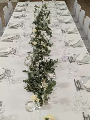 Centre de table bohème avec roses blanches, eucalyptus et pampas pour un mariage élégant au Château Bone à Gauriac.