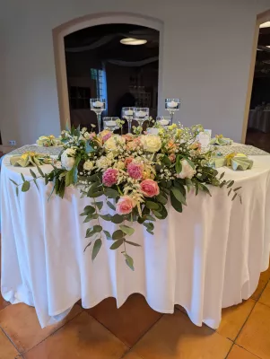 Centre de table champêtre sophistiqué avec roses, lisianthus et eucalyptus pour table d'honneur.