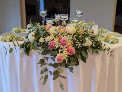 Centre de table champêtre sophistiqué avec roses, lisianthus et eucalyptus, vue rapprochée.