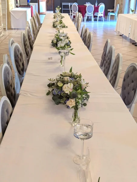 Centre de table classique pour mariage, mélange de roses creme, hortensias bleus et eucalyptus, au Domaine de Valmont.