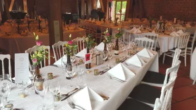 Centre de table de mariage classique, avec des roses roses claires et fuchsia, du feuillage vert et des petites fleurs blanches.