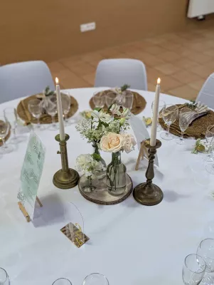 Sophisticated country-style table centrepiece with cream roses, gypsophila, and eucalyptus for a wedding.