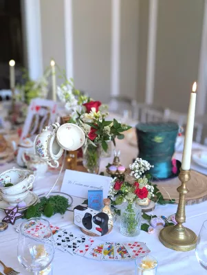 Sophisticated rustic table centrepiece with red roses and gypsophila, Alice-themed, wedding.